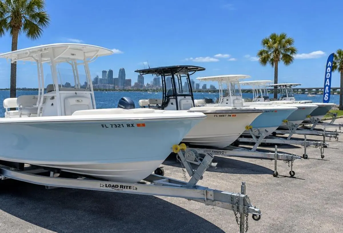 Used center console boats on trailers at a sunny Tampa Bay waterfront lot