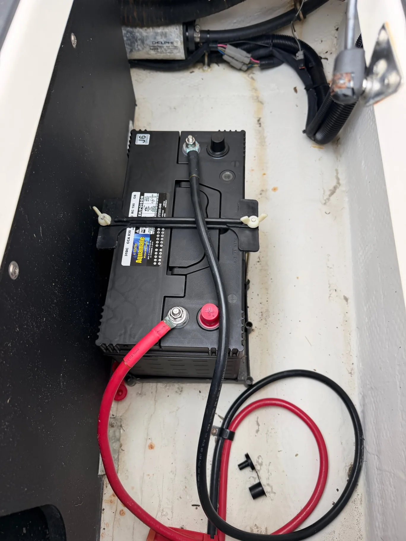 New marine battery installed and secured in a battery compartment
