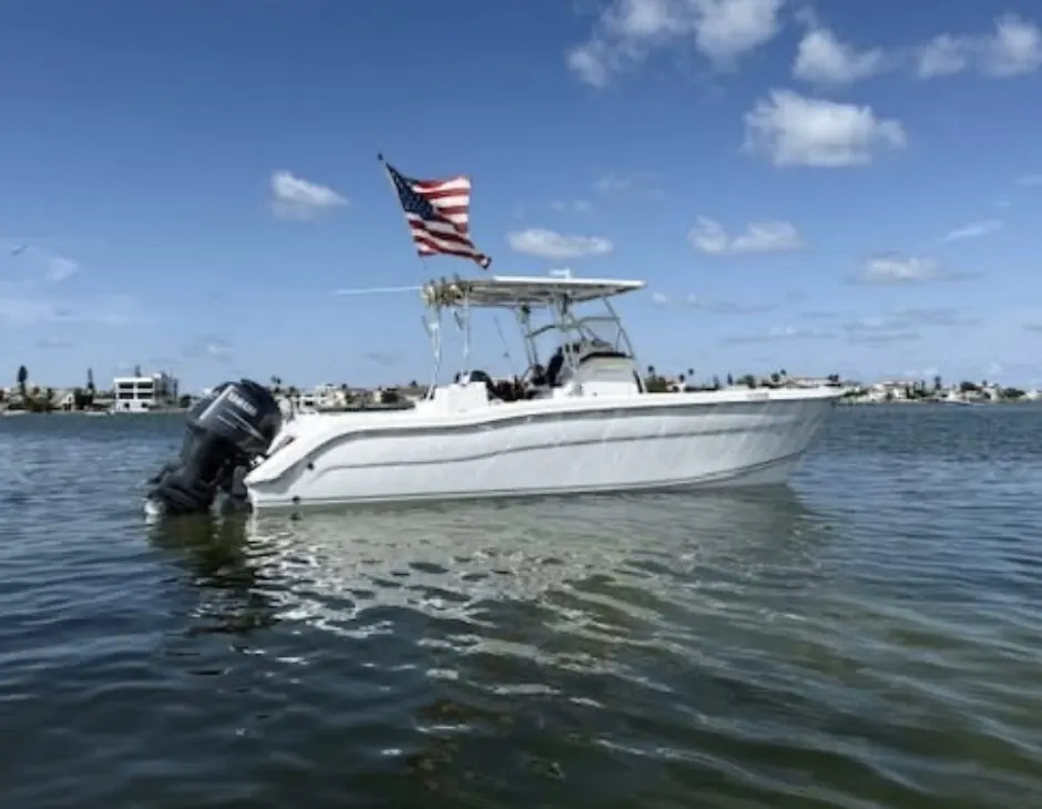 Center console boat with an outboard anchored on Tampa Bay under a blue sky