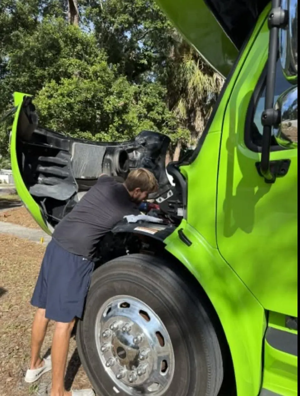 Ethan of EZ Mobile Marine working under an open engine hood