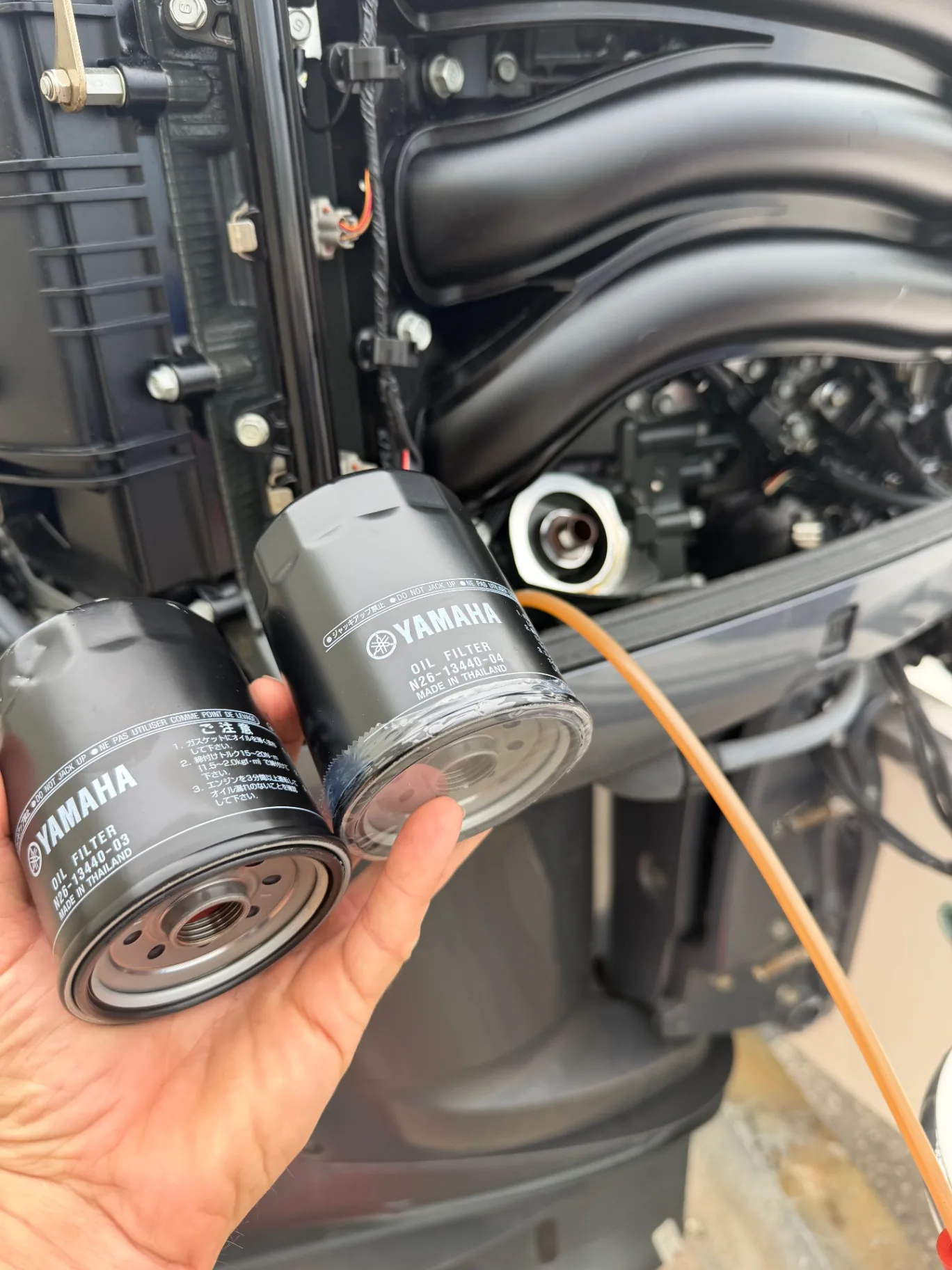 New oil and fuel filters laid out for an outboard service