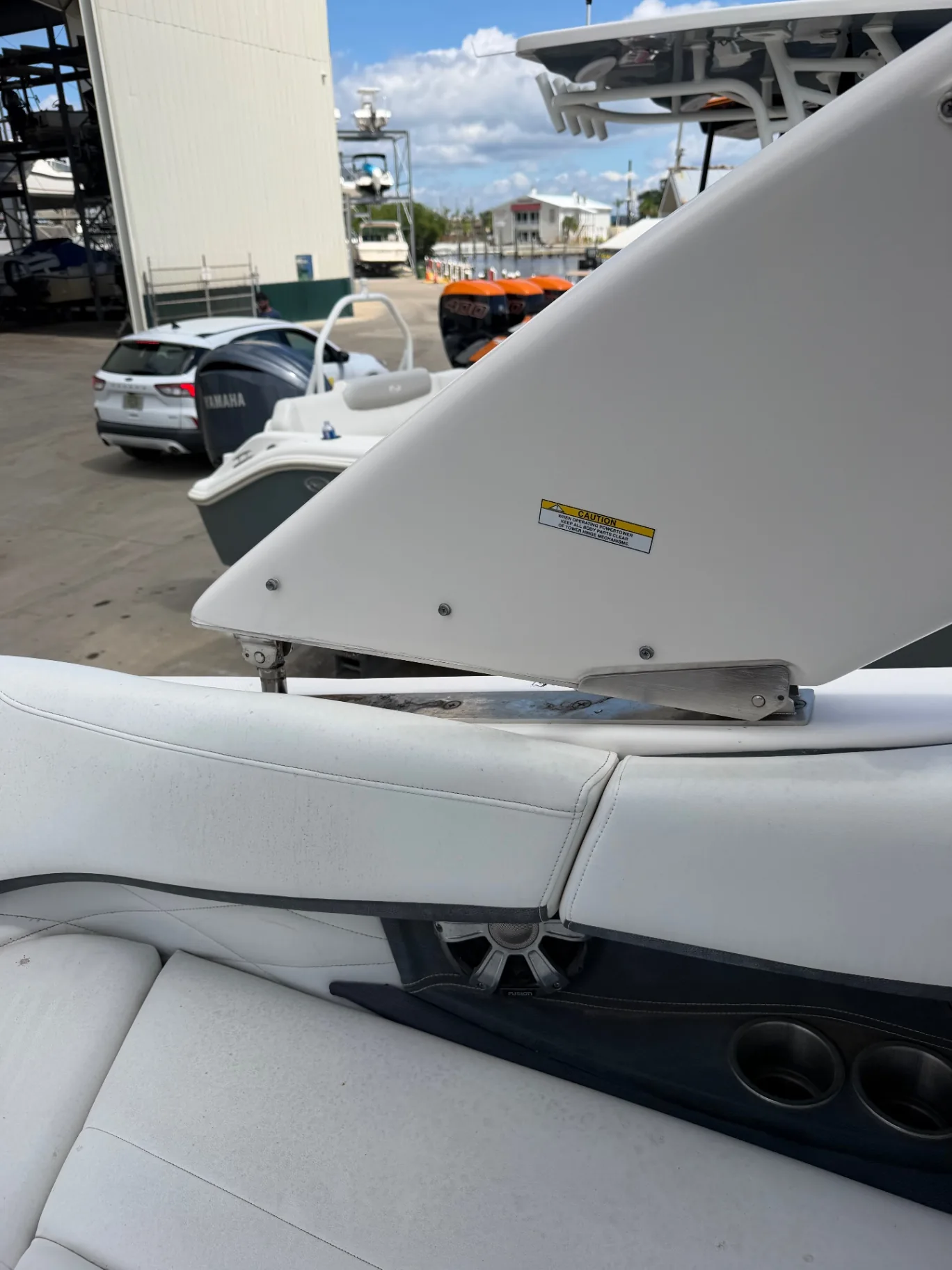 Center console with twin outboards at a marina rack yard on a sunny day