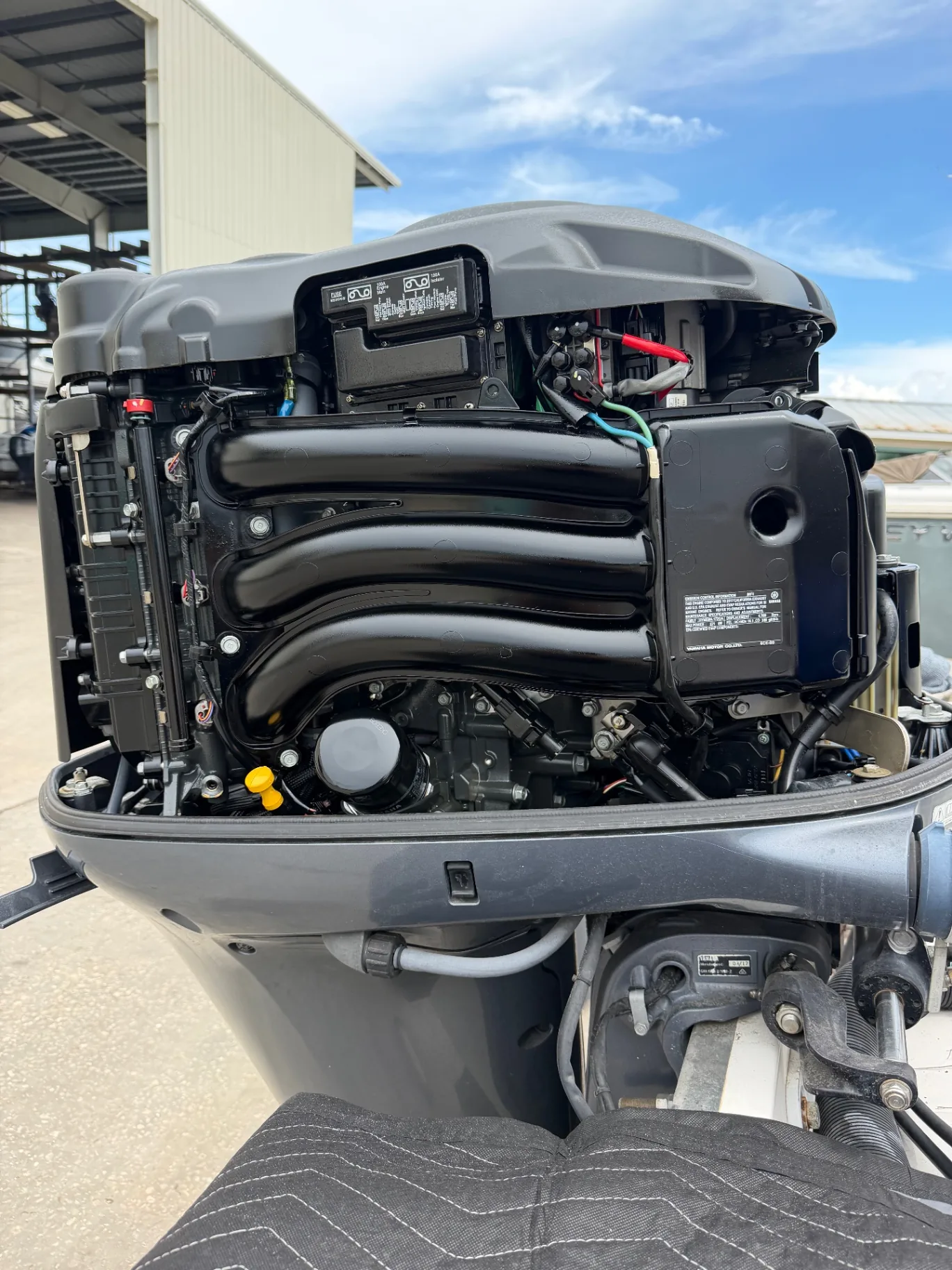 Clean outboard powerhead with the cowling removed against a blue sky