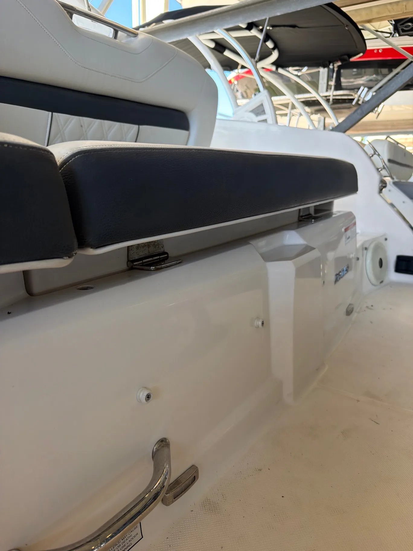 Outboard with its cowling off being serviced at the boat ramp