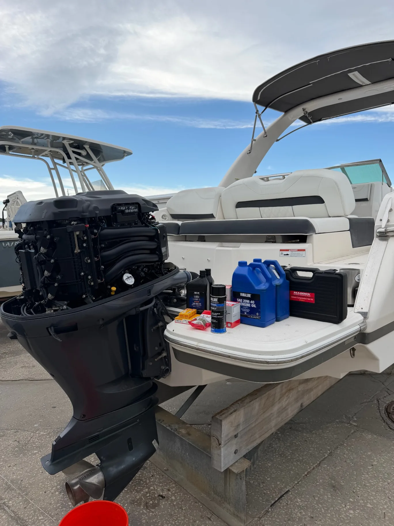 Outboard with its cowling removed and a compression test kit ready during a pre-purchase inspection