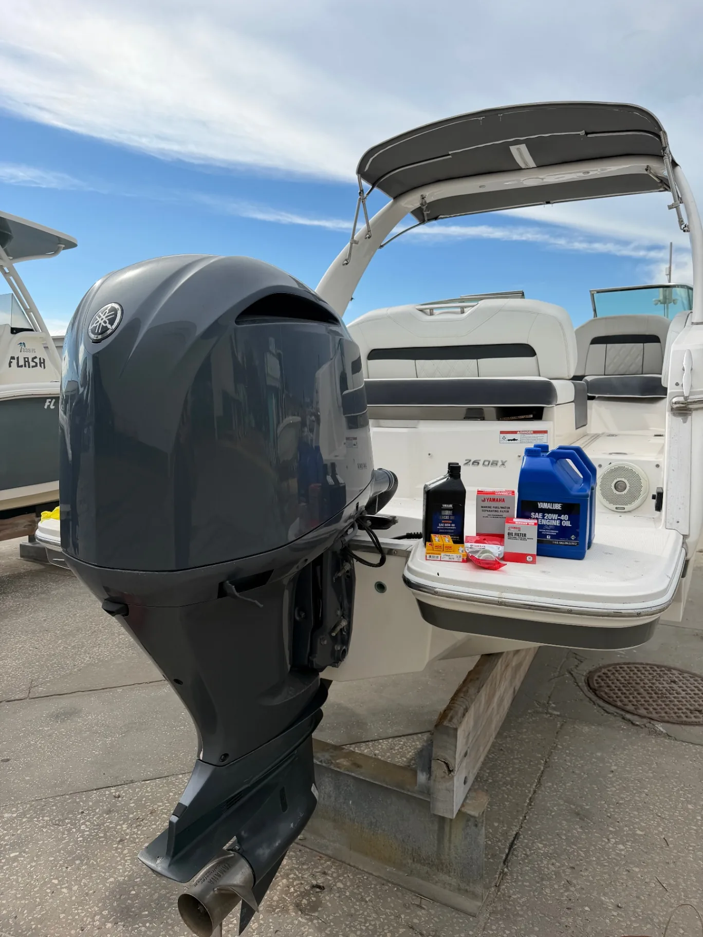 Yamaha outboard with oil, filters, and spark plugs laid out for a scheduled hour service