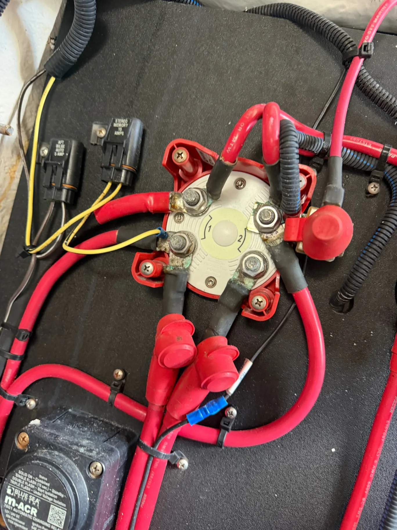Battery switch and charging relay wiring with red cable runs during an electrical job